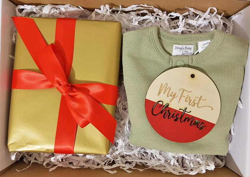 babys first christmas gift box with wrapped gift clothing and plaque